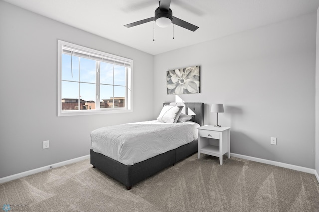 carpeted bedroom with ceiling fan and baseboards