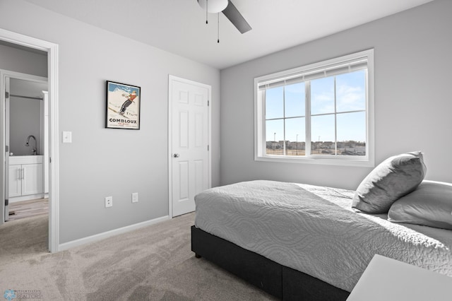 carpeted bedroom with ceiling fan, baseboards, and a sink