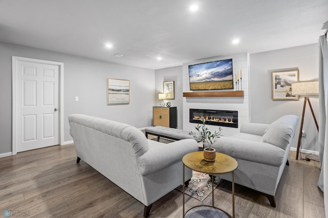 living room featuring recessed lighting, a large fireplace, baseboards, and wood finished floors