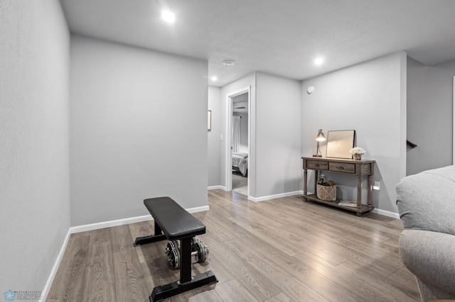 exercise room with recessed lighting, wood finished floors, and baseboards