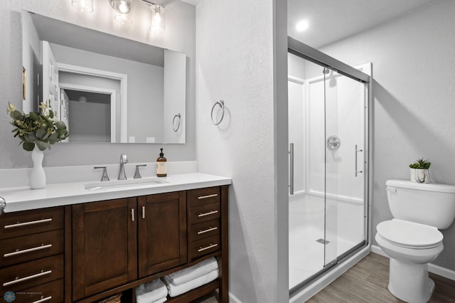 full bathroom with toilet, vanity, and a shower stall