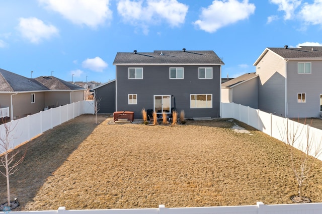 rear view of house with a fenced backyard