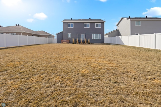 back of house featuring a fenced backyard and a yard