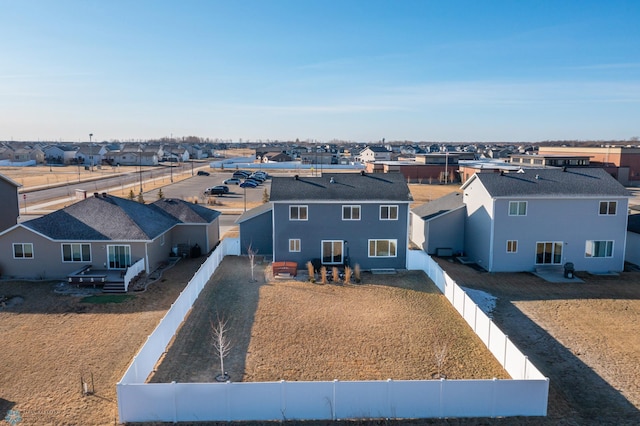 view of front of property featuring a fenced backyard, a residential view, and driveway