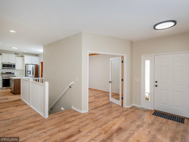 entryway with recessed lighting, baseboards, and light wood-style floors