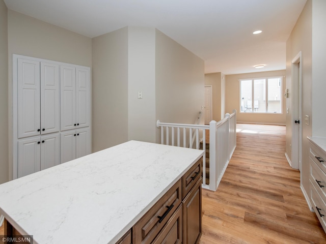 interior space featuring recessed lighting, light stone countertops, light wood-style floors, and white cabinetry