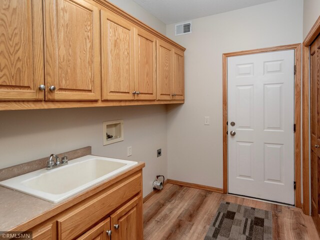 laundry room featuring visible vents, cabinet space, a sink, washer hookup, and electric dryer hookup