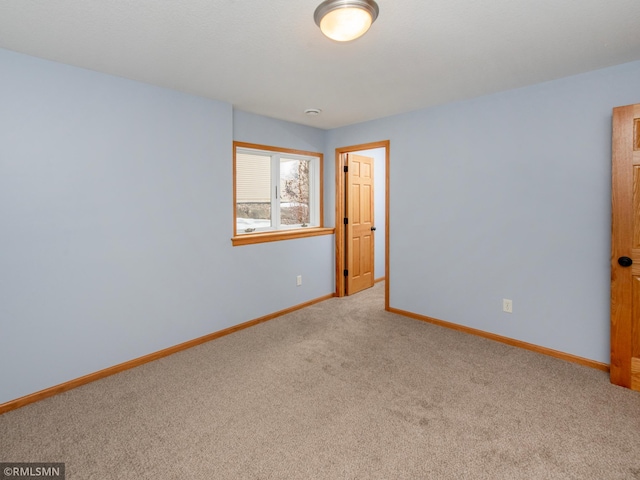 empty room with baseboards and carpet floors