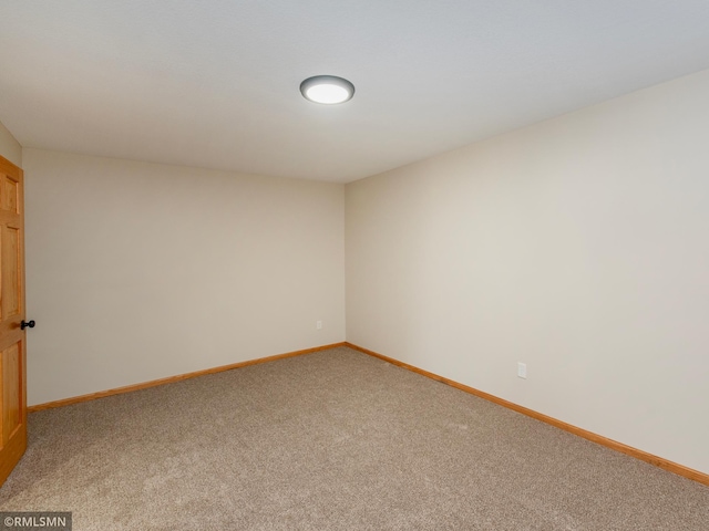 empty room featuring light colored carpet and baseboards