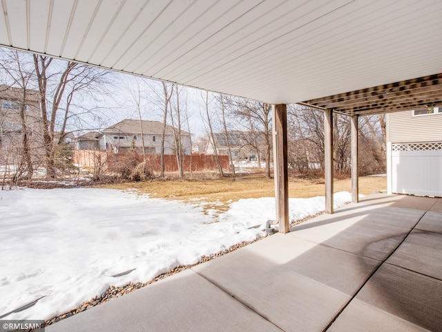 snow covered patio featuring fence