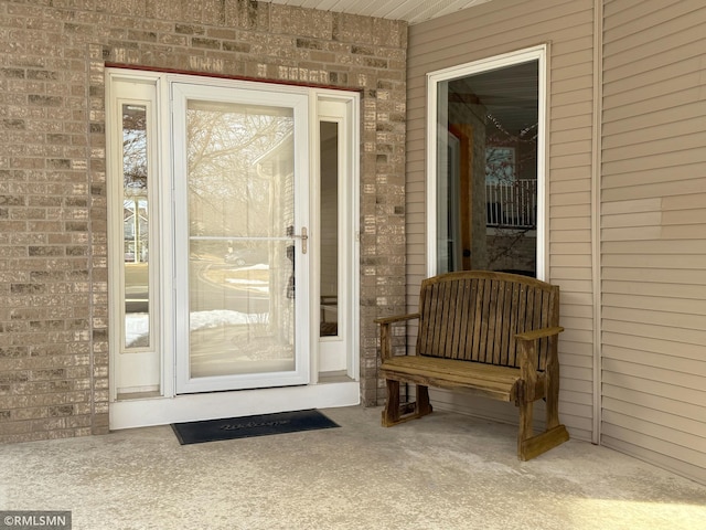 doorway to property with brick siding