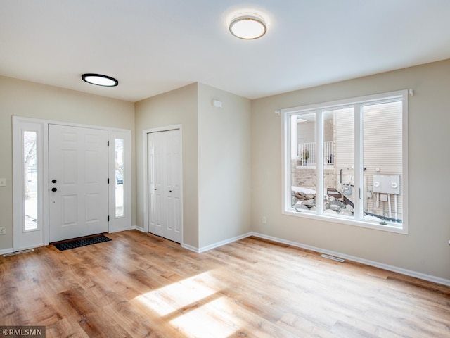 foyer featuring visible vents, baseboards, and light wood-style flooring