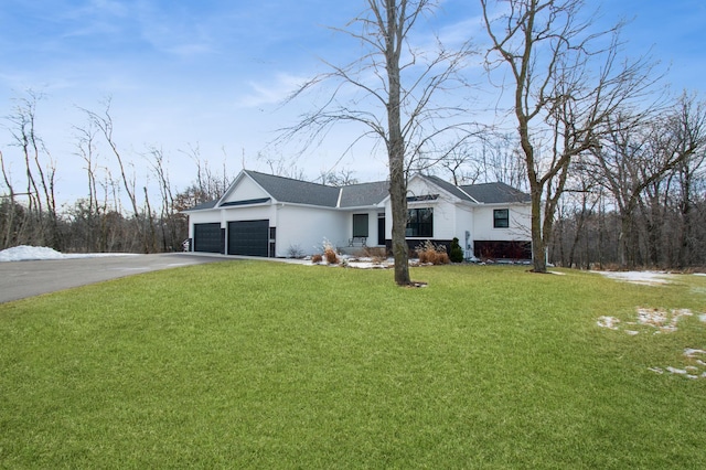 ranch-style house featuring aphalt driveway, a front yard, and an attached garage