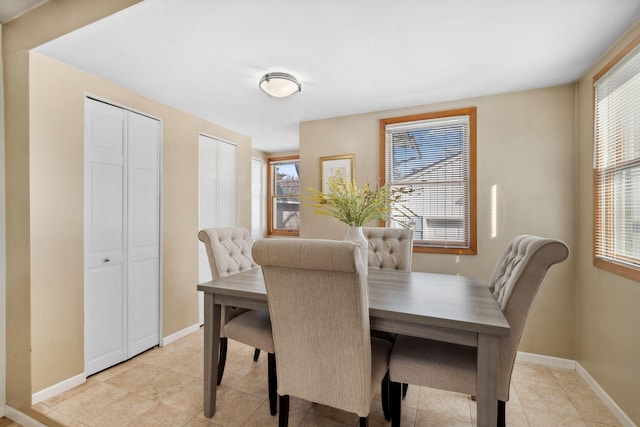 dining space with light tile patterned flooring, plenty of natural light, and baseboards