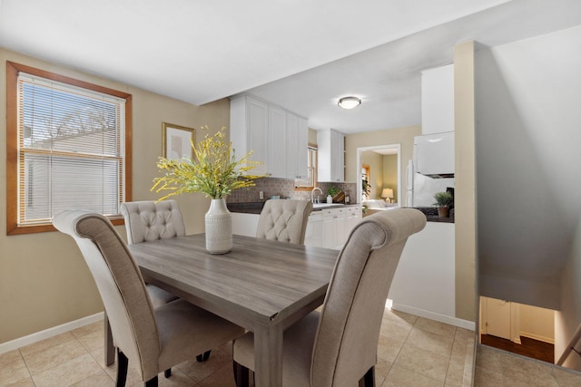 dining area featuring light tile patterned flooring and baseboards