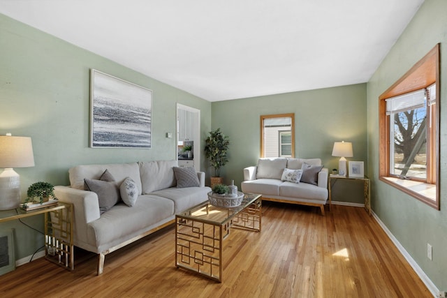 living area with wood finished floors, baseboards, and a wealth of natural light