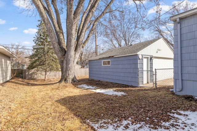 view of yard with an outbuilding, a detached garage, and fence