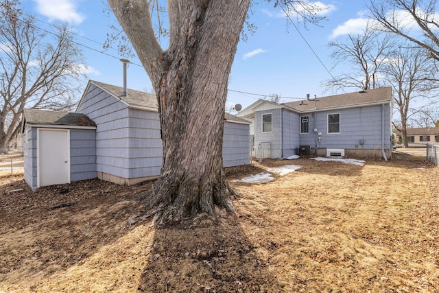 rear view of house with fence and central AC