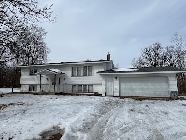 raised ranch featuring a chimney and a garage