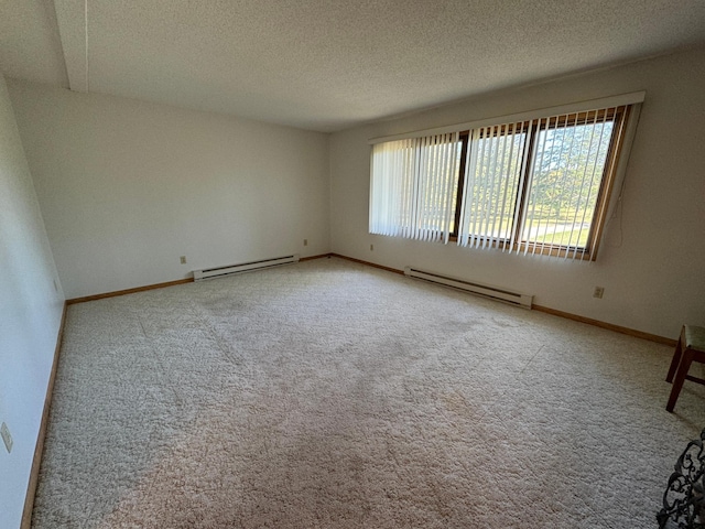 empty room with baseboard heating, a textured ceiling, baseboards, and carpet floors