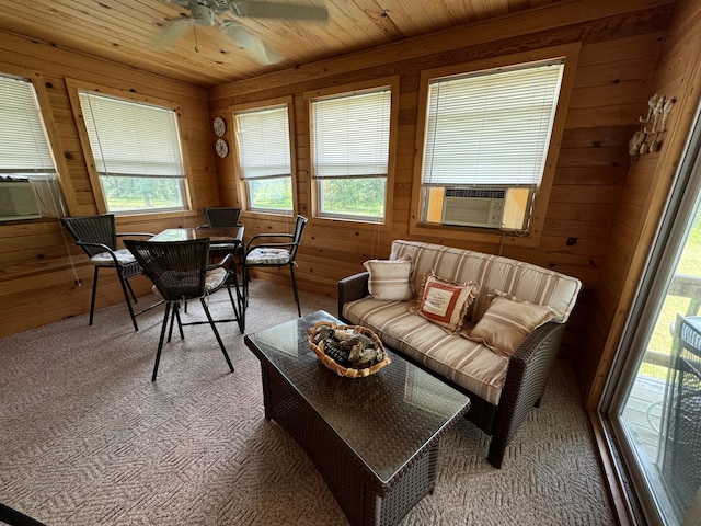 carpeted living area featuring wooden ceiling, wooden walls, cooling unit, and a ceiling fan