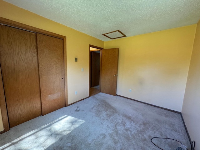 unfurnished bedroom with a closet, baseboards, a textured ceiling, and carpet