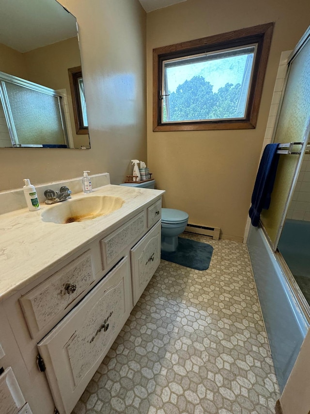 bathroom featuring vanity, toilet, bath / shower combo with glass door, and a baseboard radiator