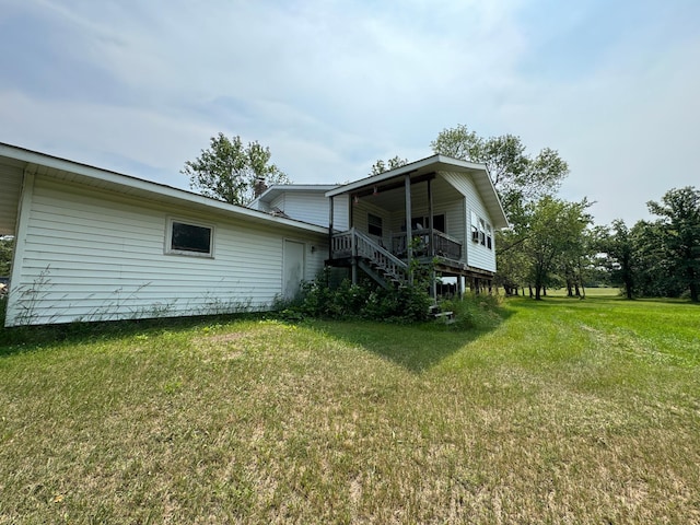 back of house featuring stairs and a yard