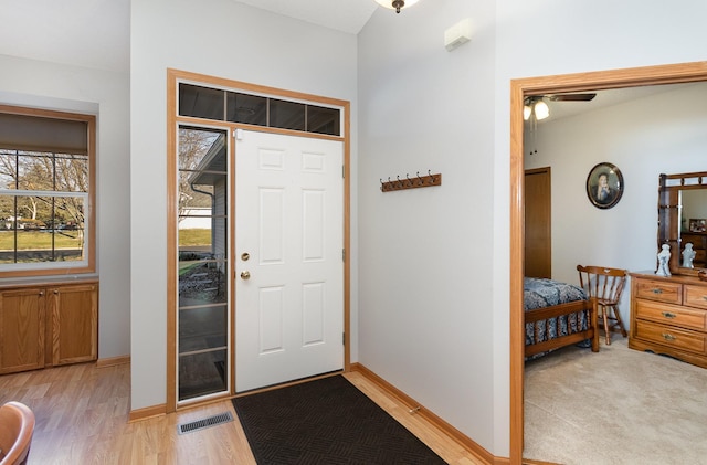 foyer featuring light wood finished floors, visible vents, and baseboards