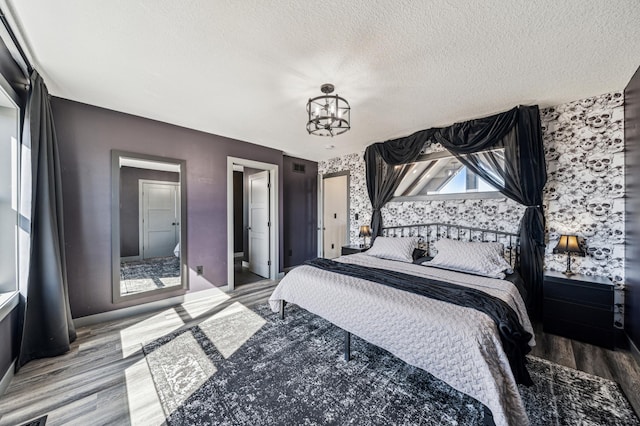 35647 Oxford Ave, Chisago Lake Twp, MN 55012 - bedroom featuring wood finished floors, a chandelier, a textured ceiling, and baseboards