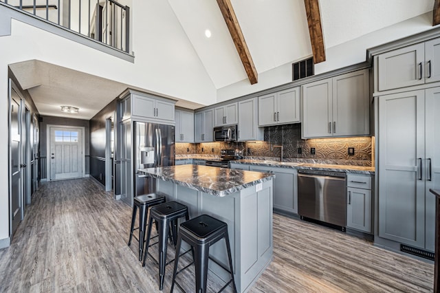 35647 Oxford Ave, Chisago Lake Twp, MN 55012 - kitchen with stainless steel appliances, gray cabinetry, a kitchen breakfast bar, wood finished floors, and beam ceiling