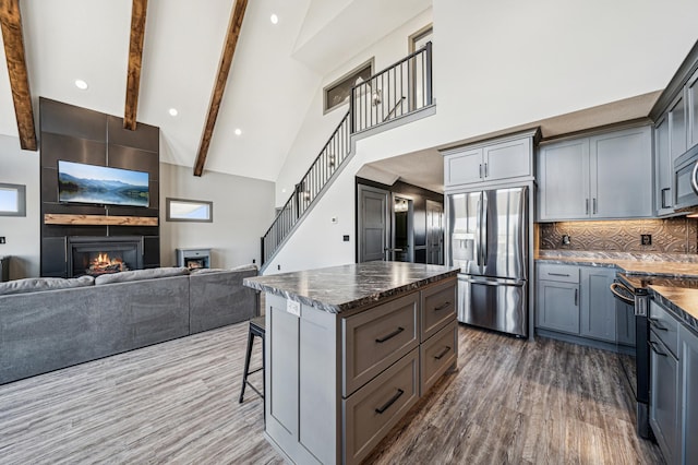 35647 Oxford Ave, Chisago Lake Twp, MN 55012 - kitchen with stainless steel fridge, range with electric stovetop, gray cabinetry, dark wood finished floors, and a fireplace