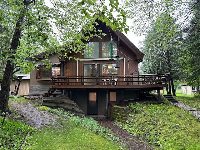 back of house with a wooden deck and stairs