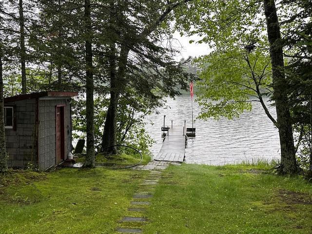 exterior space with an outbuilding, a storage shed, and a water view