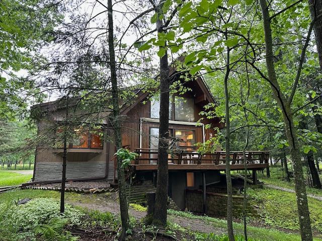 rear view of house featuring a deck and stone siding