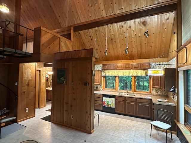 kitchen featuring light countertops, wooden walls, light floors, and a sink