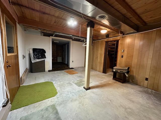 basement with wooden ceiling, wooden walls, and visible vents