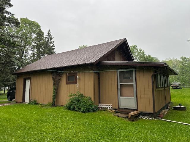 view of home's exterior featuring a yard and roof with shingles