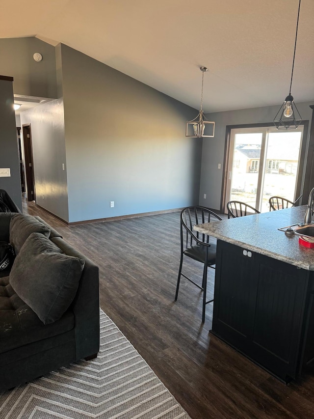 dining space with vaulted ceiling, baseboards, and dark wood-style flooring