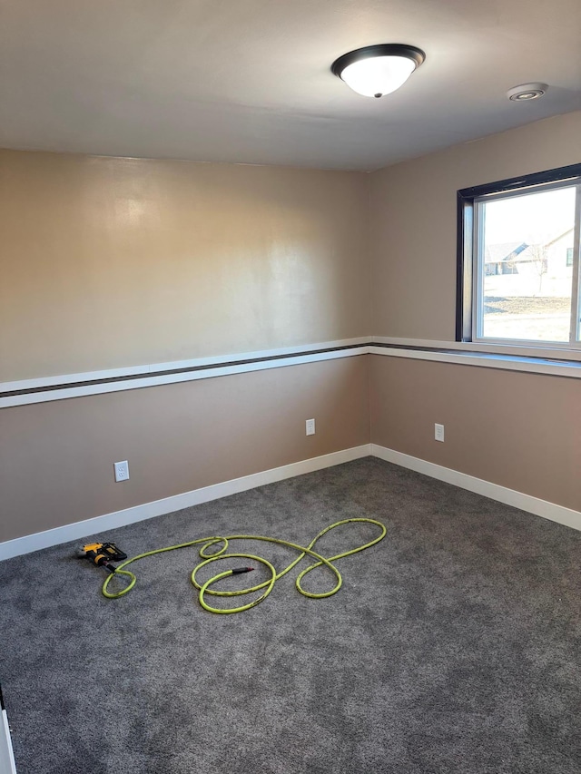 carpeted spare room with baseboards