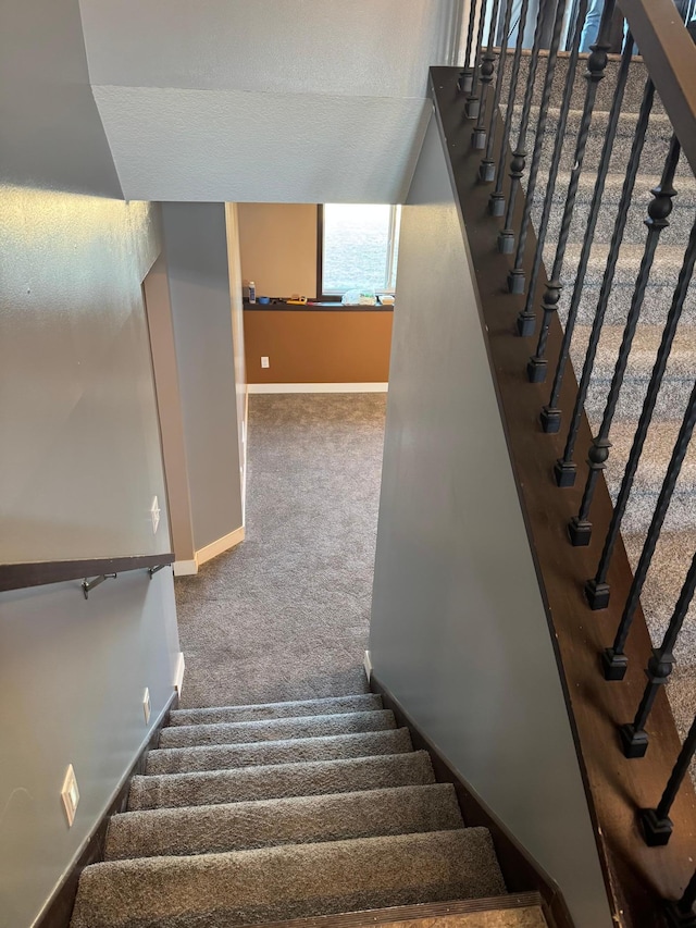 stairway featuring carpet and baseboards