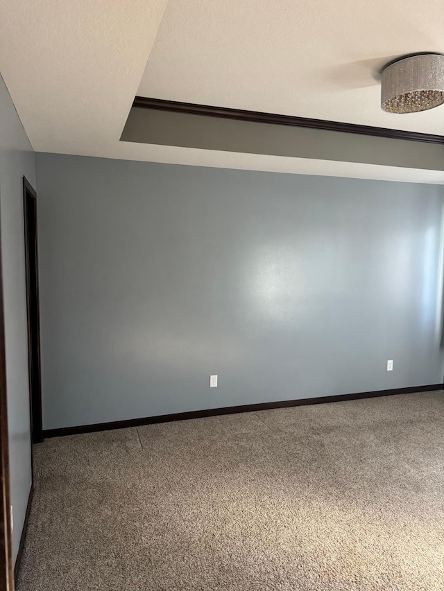 empty room featuring carpet, baseboards, and a textured ceiling
