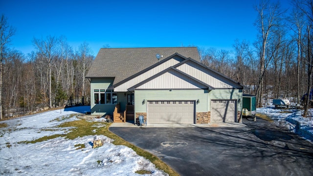 view of front of property with aphalt driveway, stone siding, and a garage