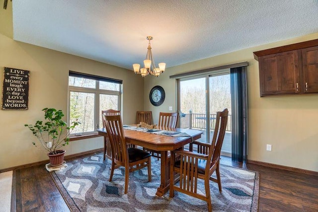 dining area featuring baseboards, a textured ceiling, a chandelier, and dark wood-style flooring