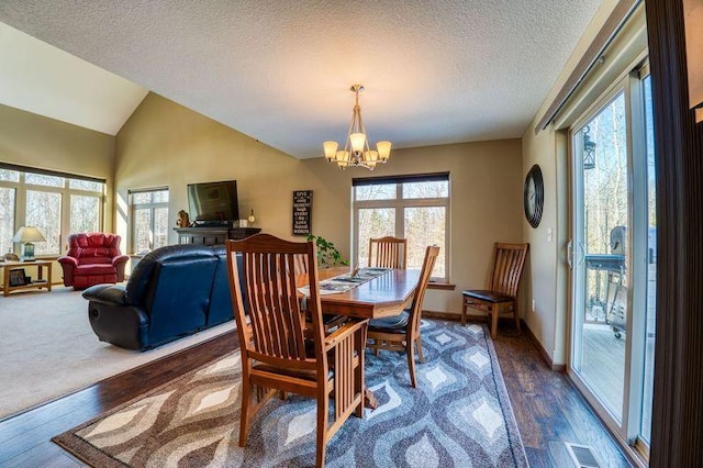 dining area with a wealth of natural light, visible vents, an inviting chandelier, and lofted ceiling