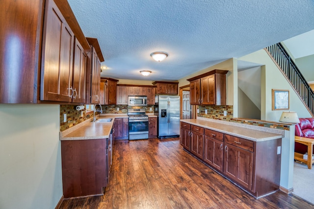 kitchen with dark wood-type flooring, light countertops, appliances with stainless steel finishes, and a sink