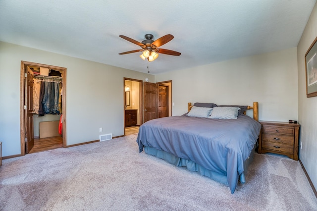 carpeted bedroom with baseboards, visible vents, a spacious closet, a closet, and ensuite bathroom