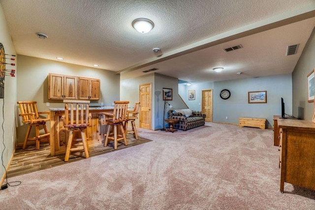 dining space with a dry bar, visible vents, and light carpet