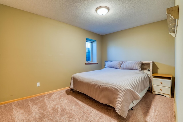 carpeted bedroom featuring baseboards and a textured ceiling