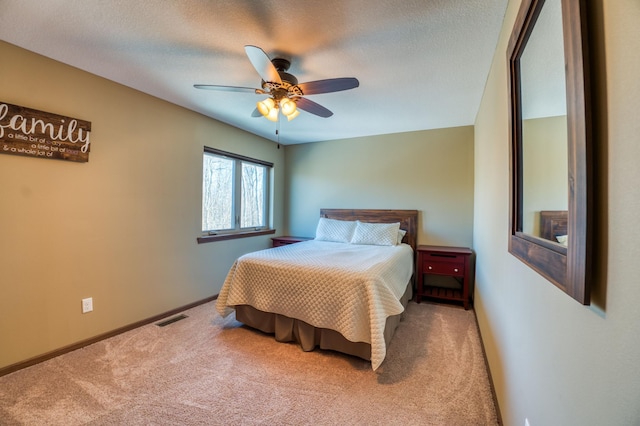 bedroom featuring visible vents, a ceiling fan, a textured ceiling, carpet floors, and baseboards